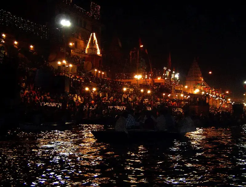 Ghat lit with thousands of diyas on the river at night (Dev Deepawali, Varanasi)